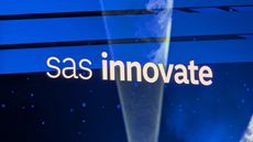 The words 'SAS innovate' on a blue screen at SAS Innovate 2025, with a light beam intersecting the words and highlighting the dry ice in the keynote ballroom.