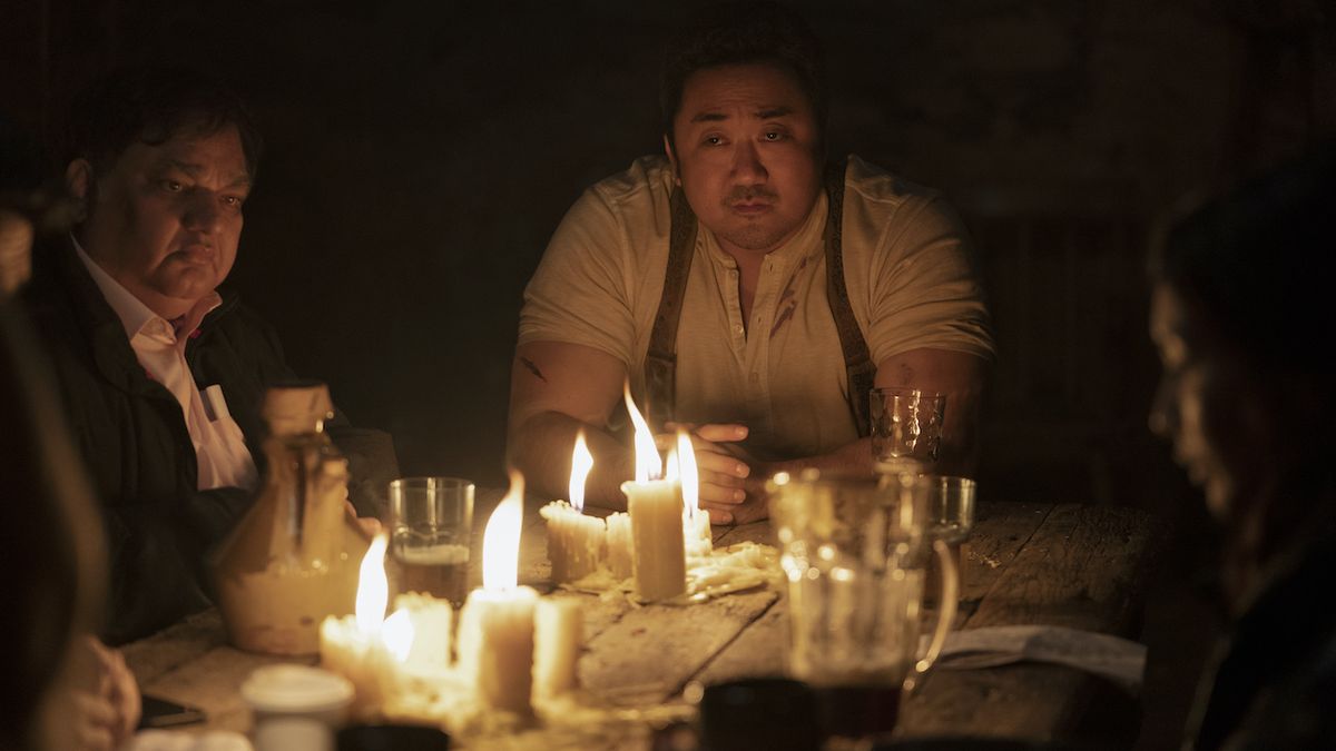 Don Lee as Gilgamesh sitting next to lit candles in Eternals