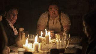 唐·李在《永恒》中饰演吉尔伽美什，坐在点燃的蜡烛旁