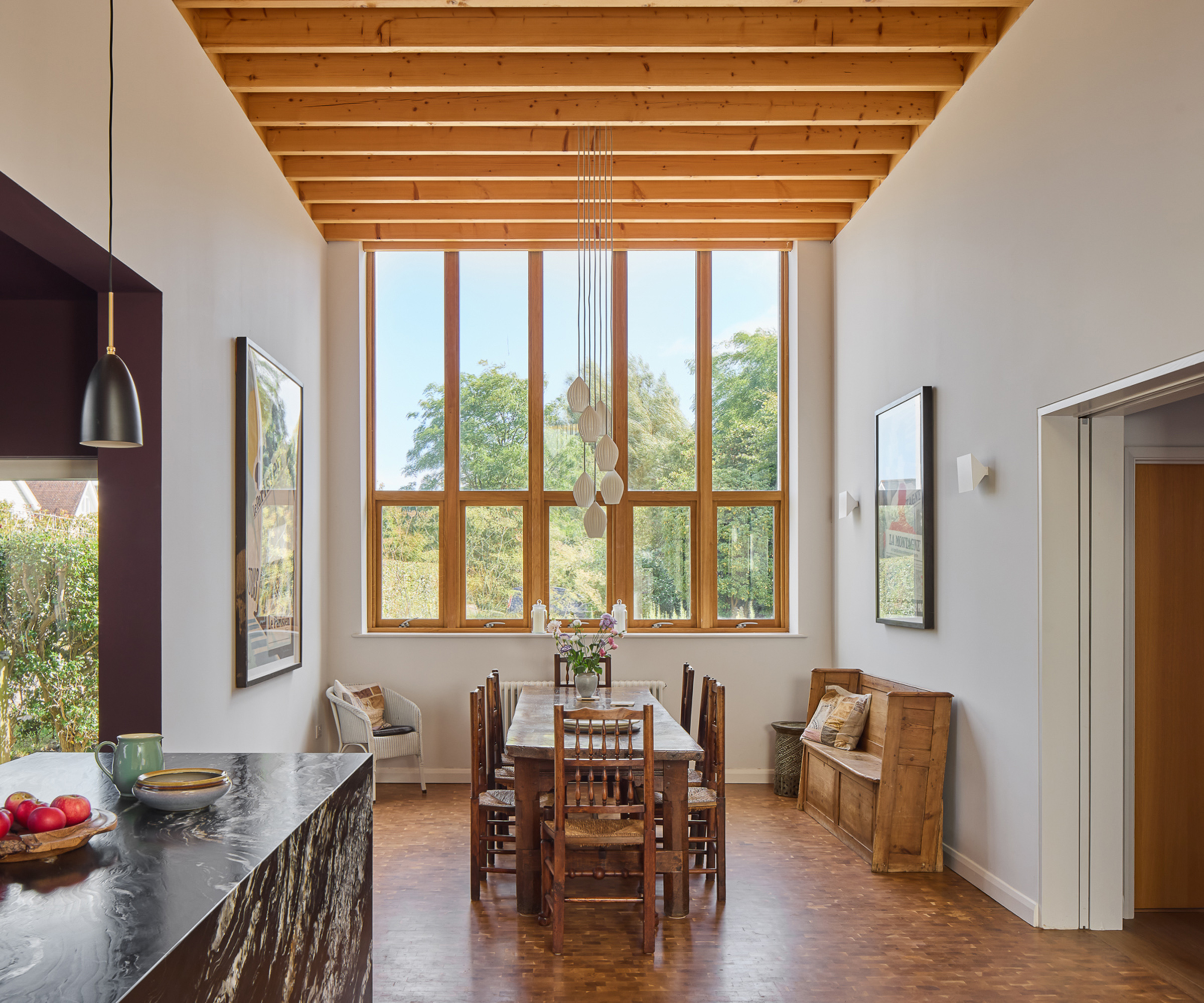 A dining area in a renovation house with exposed timber beams on the ceiling