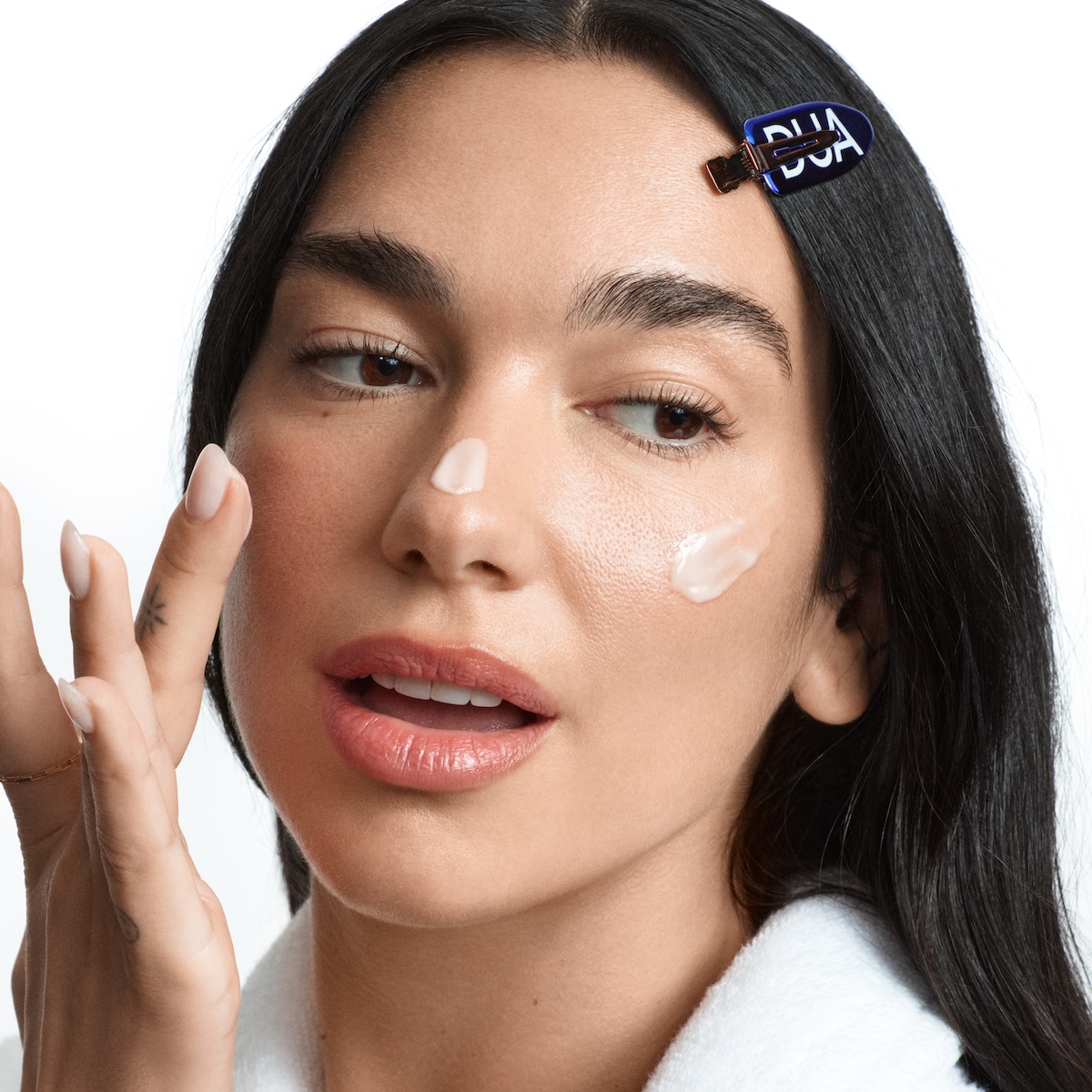 Dua Lipa applying her new Dua skincare products.