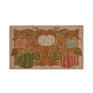 A brown coir doormat with green, white, and pink pumpkin illustrations on it