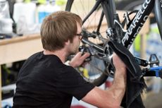 Man making adjustments to bicycle