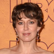 Carrie Coon with a pixie haircut and dangly earrings. 