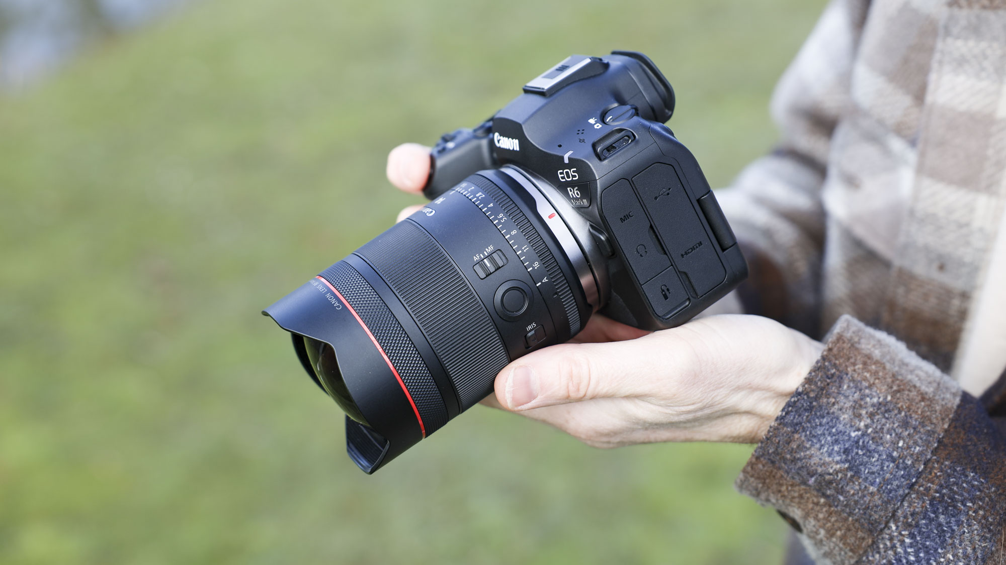 Canon RF 14mm F1.4L VCM lens in photographer Tim Coleman's hands, attached to an EOS R5 mark II