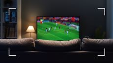 picture of football playing on flatscreen TV in front room with sofa and lamp