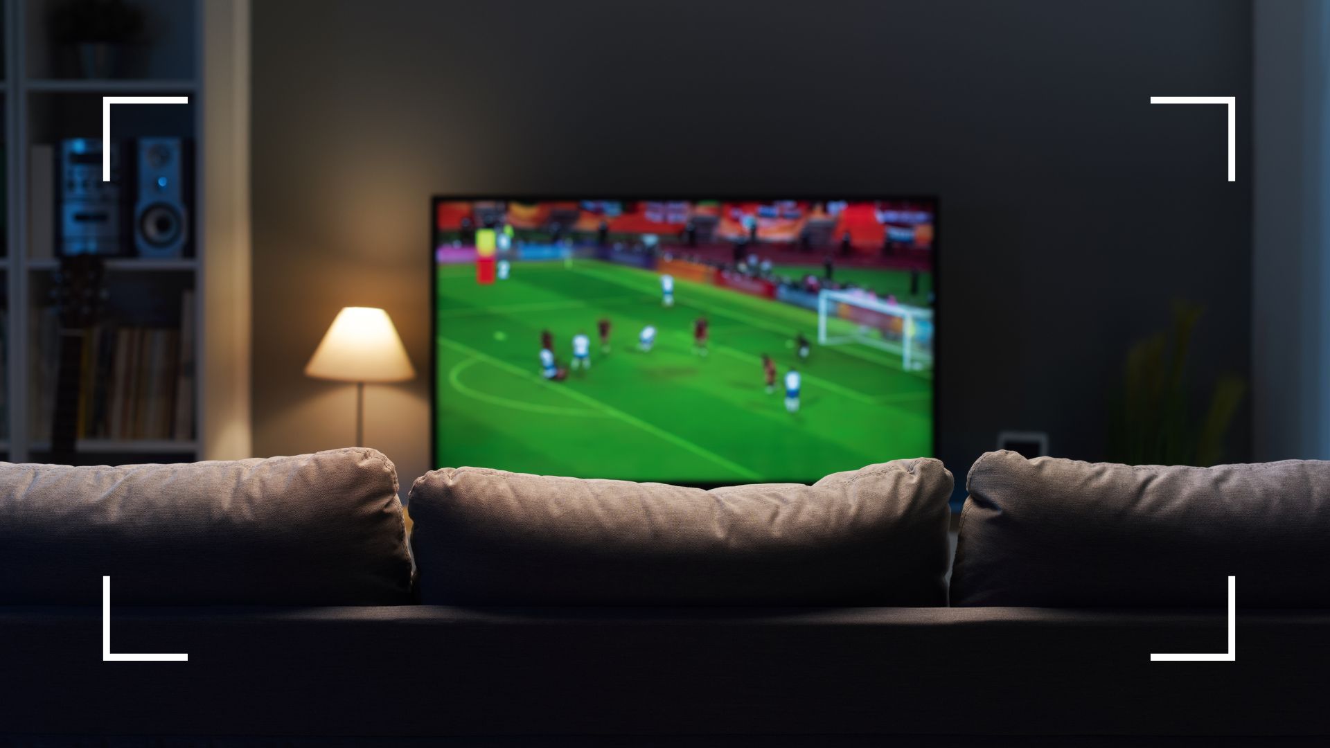 picture of football playing on flatscreen TV in front room with sofa and lamp