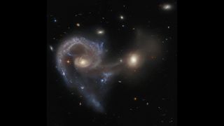 Arp 107, a celestial object that comprises a pair of galaxies in the midst of a collision, with a Seyfert galaxy on the left.