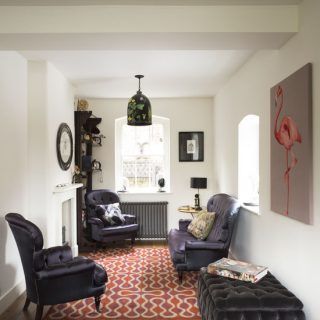 living room with black sofa set and red printed carpet