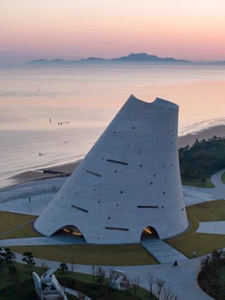 sun tower by open architecture, a curved, sloping, concrete tower, half open to the elements and looking out towards the sea