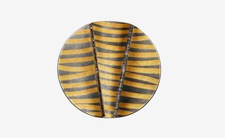 Circular disc with grey and yellow zebra stipes