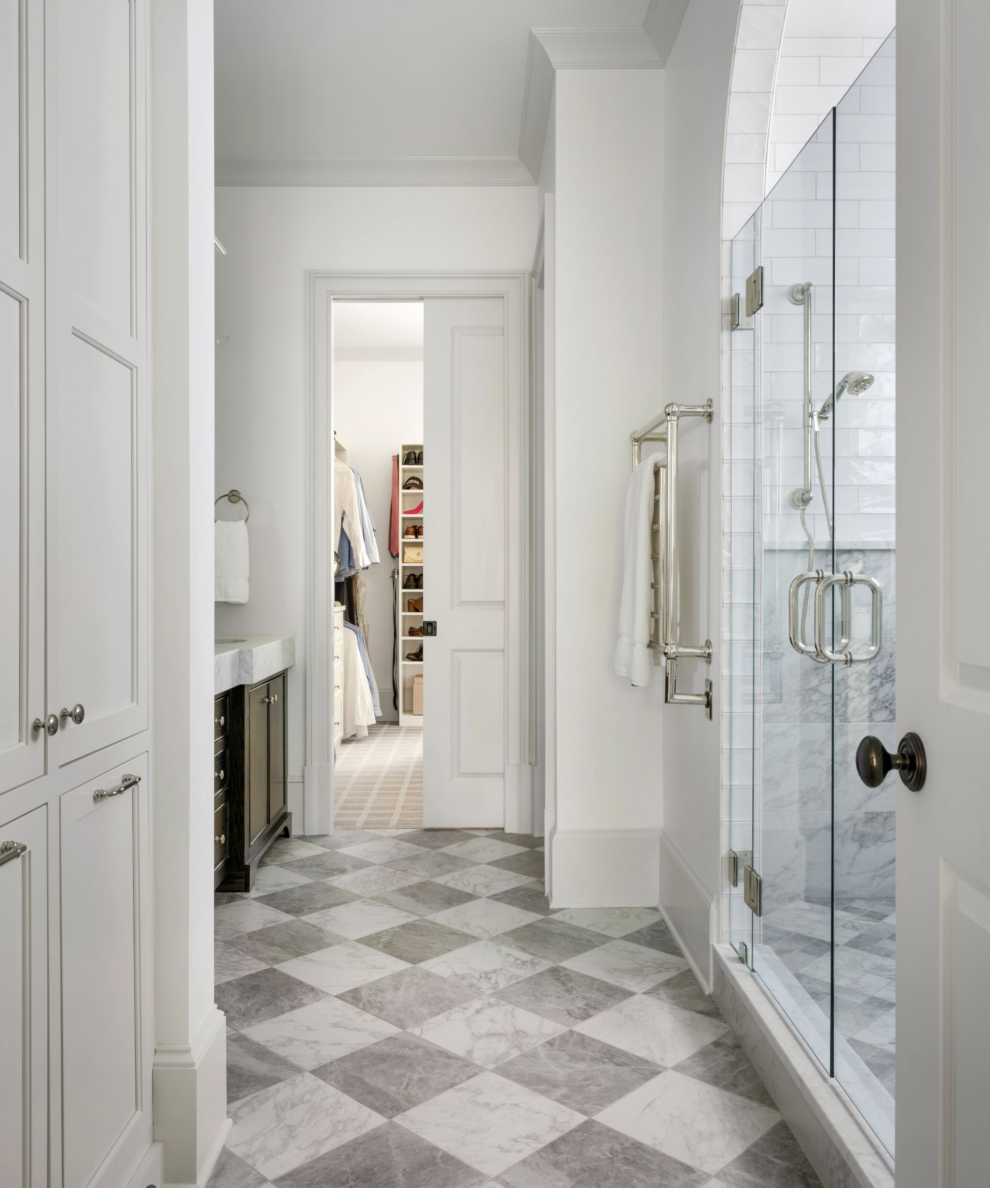 A white bathroom with gray and white marble checkerboard floor tiles