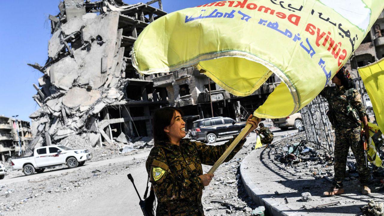 Syrian Democratic Forces fighter plants their flag at the centre of Raqqa