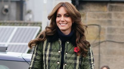Catherine, Princess of Wales, wearing a quilted jacket, smiles as she visits Outfit Moray 