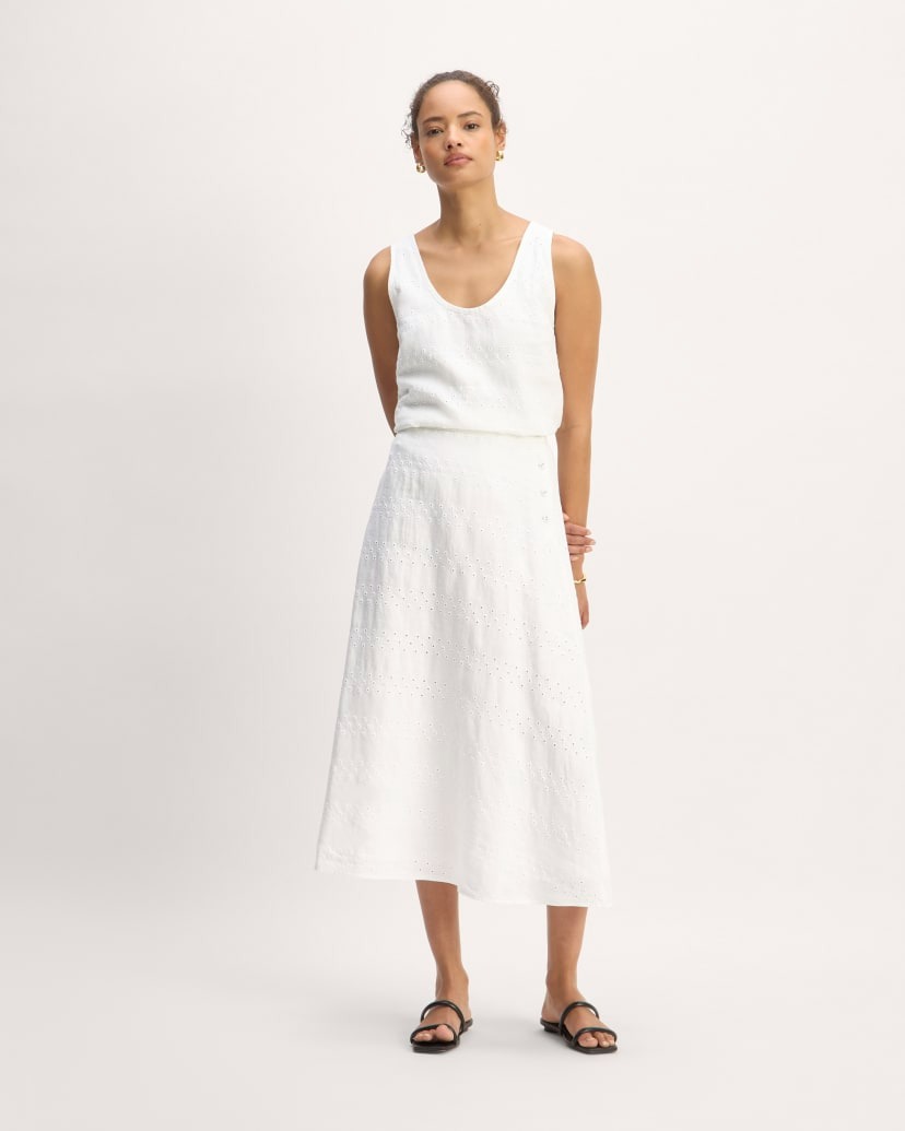a model wears a white tank top with a matching A-line midi skirt