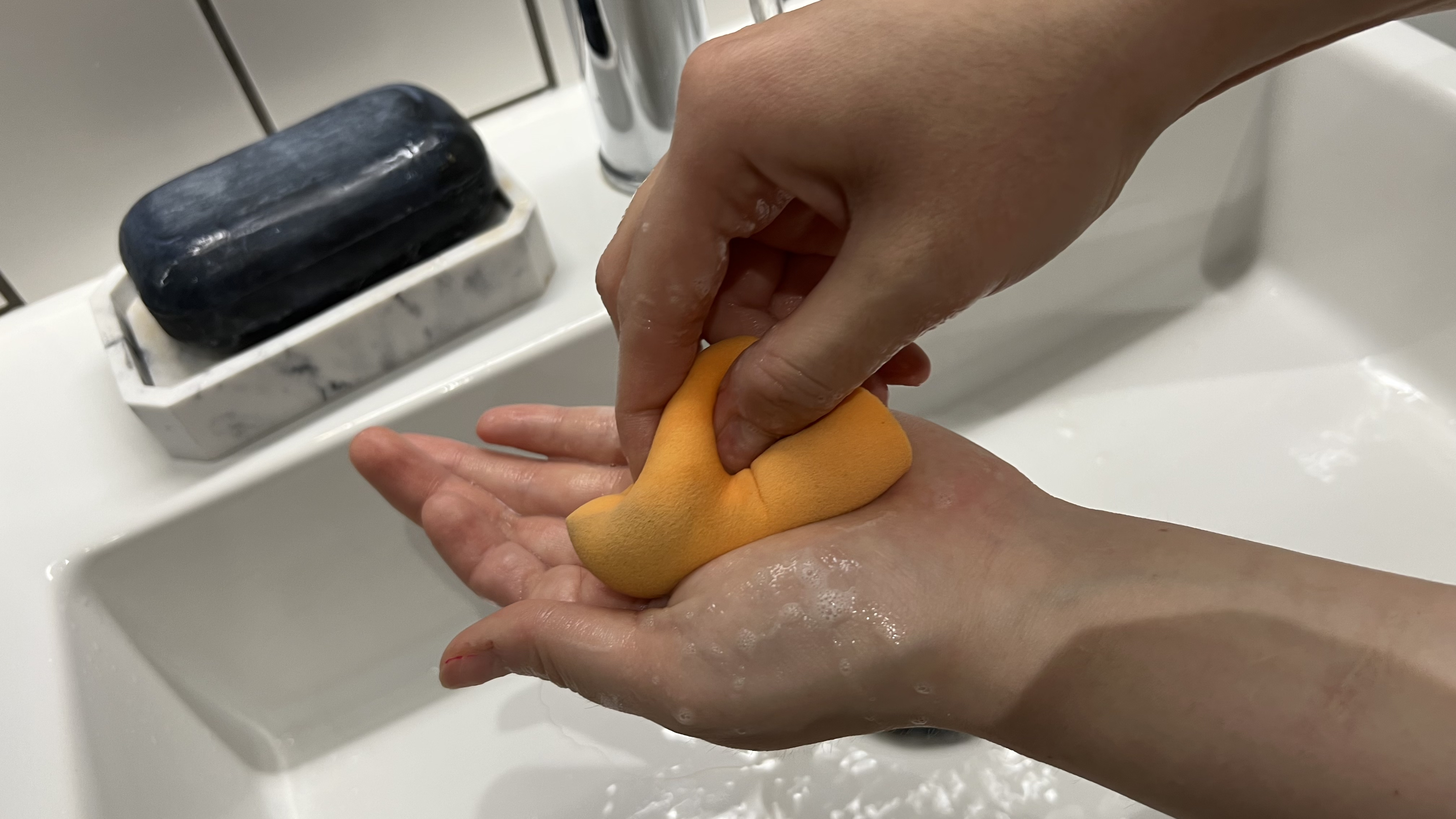 An image showing a person cleaning a Beautyblender
