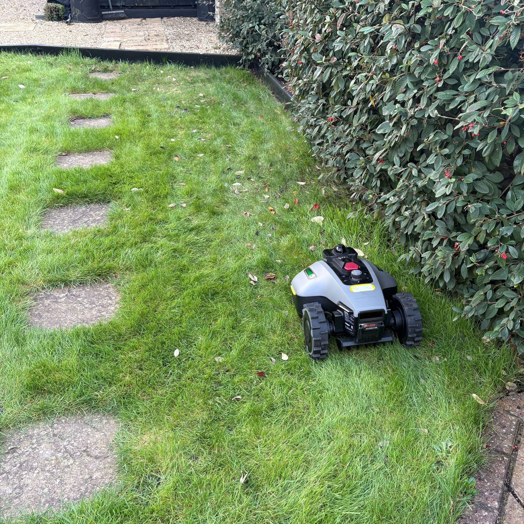 Back view of Mammotion YUKA Mini 2 1000 Robot Lawn Mower mowing under shrub