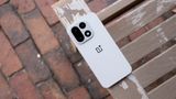 The back of the Sand Storm OnePlus 15 on a tan bench