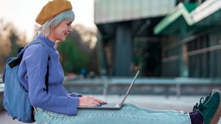 Dell XPS 13 (2022) shown being used by a woman sitting down in a staged lifestyle shot from Dell