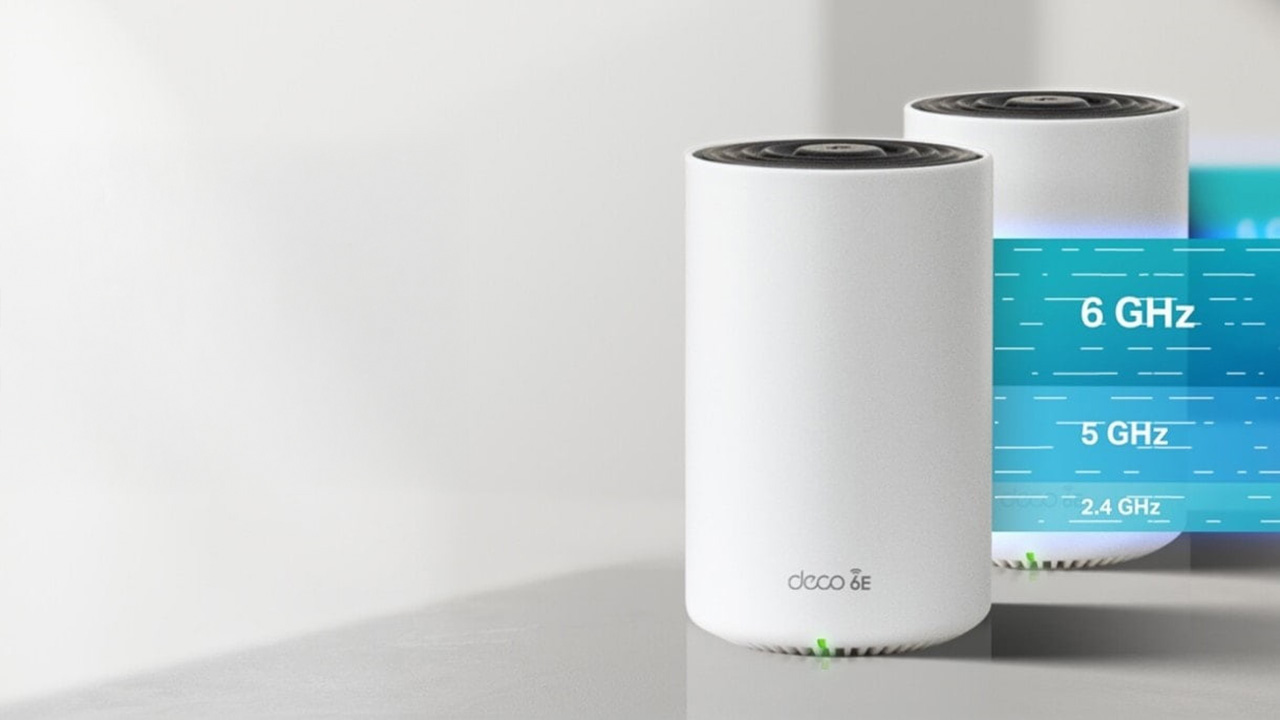 TP-Link Deco XE75 Pro mesh network on a grey desktop
