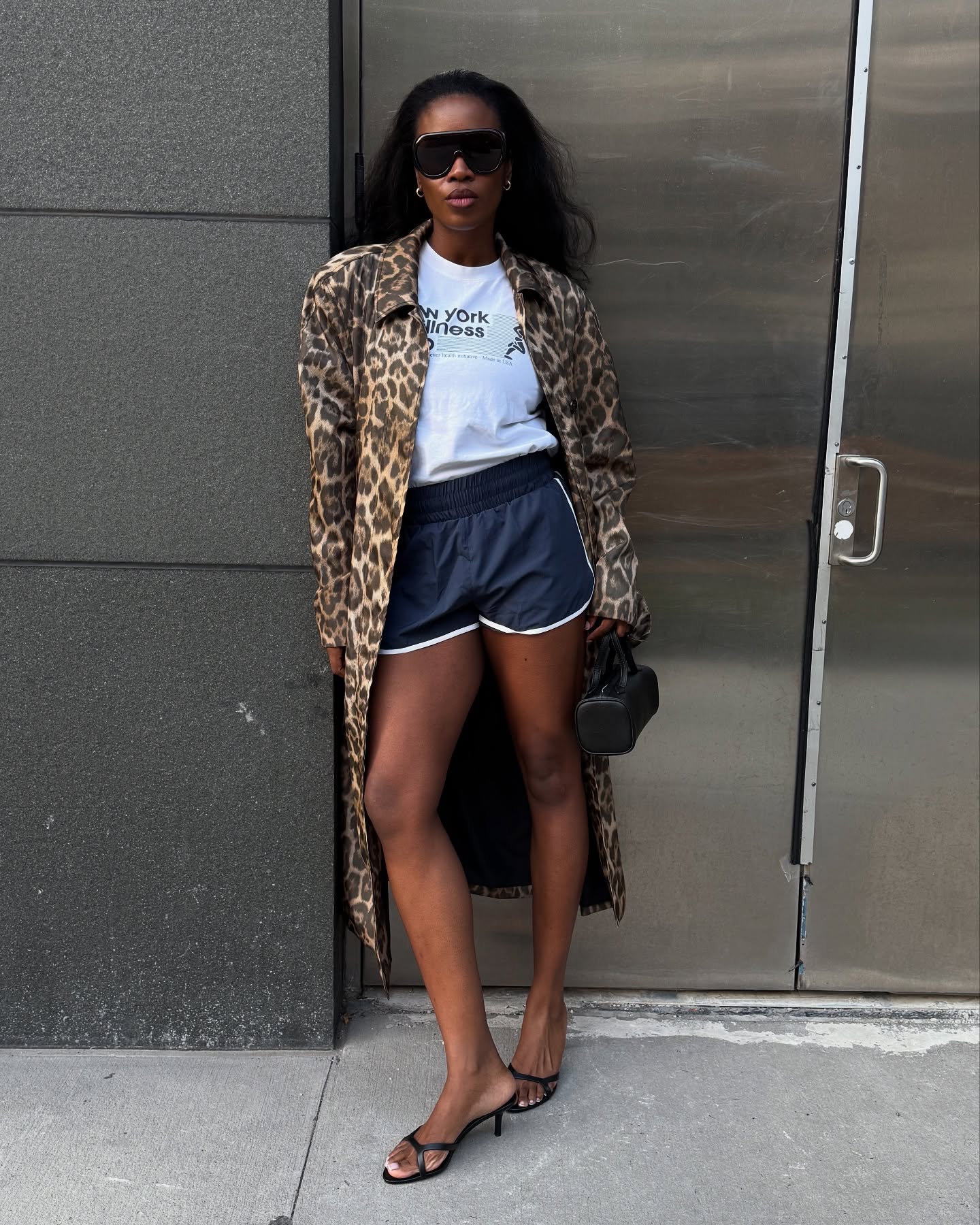 @nlmarilyn wears a white t-shirt with track shorts, kitten heels and a leopard print trench.