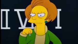 Mrs. Krabappel looking angry while standing in front of the blackboard in The Simpsons