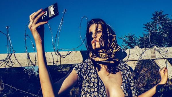 A model wears a &amp;#039;migrant chic&amp;#039; head scarf and unbuttoned shirt.