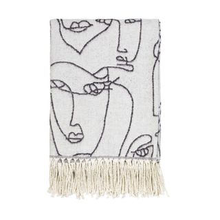 oat colored throw blanket with tassels and face outline drawing