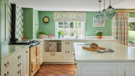 A country kitchen with white cabinets, apple green walls, and a yellow AGA