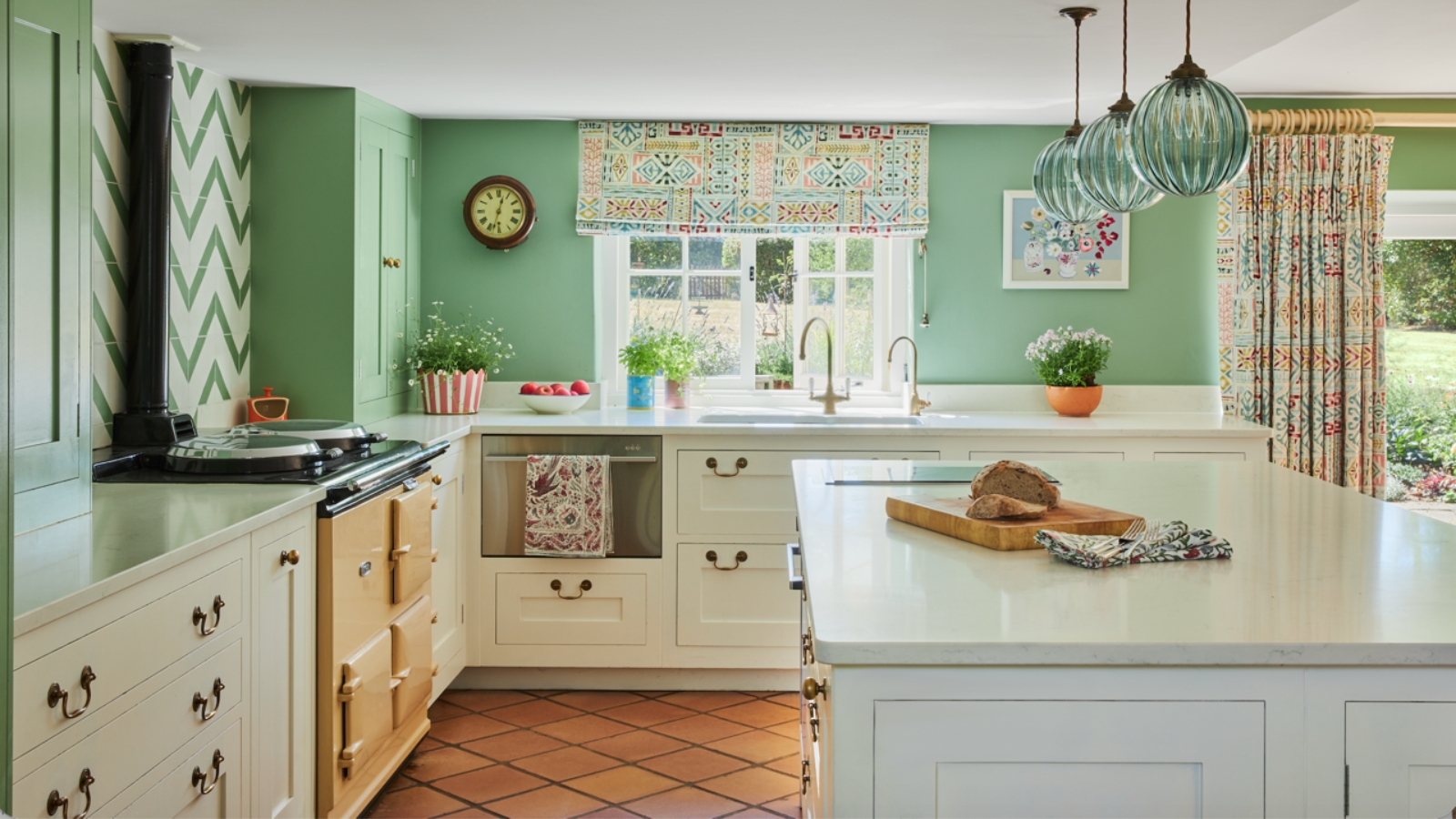 A country kitchen with white cabinets, apple green walls, and a yellow AGA