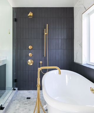 bathroom with black tile and white tub