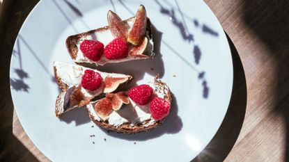 Ricotta on top of wholegrain bread with figs and berries as a collection of the best foods to eat after a workout