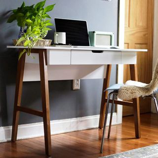 Compact desk in white with wooden legs, and discreet drawers