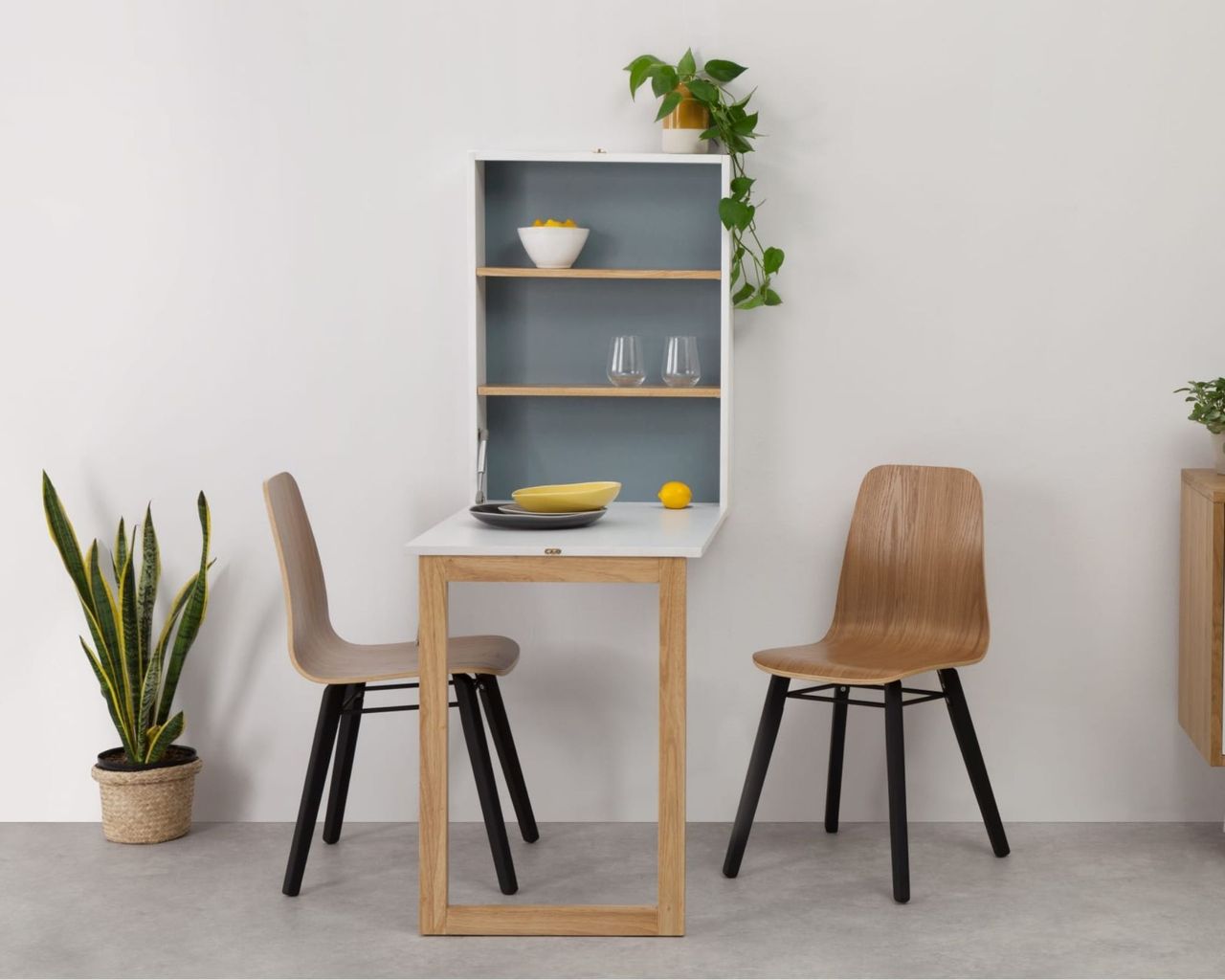 Made.com Izzy Wall Mounted Dining Table unfolded with wooden chairs and plants