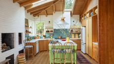 A large kitchen with white walls, wooden cabinetry, blue backsplash tiles, and a green island