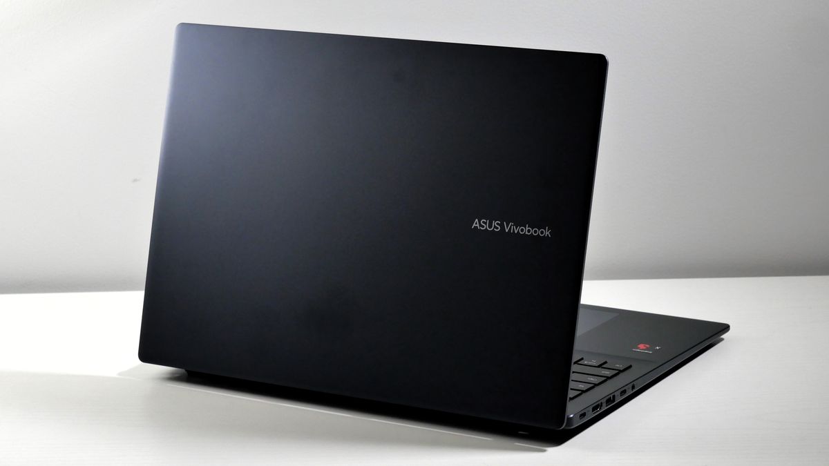 Asus Vivobook 16 (2025) open on a white table, highlighting its dark top lid.