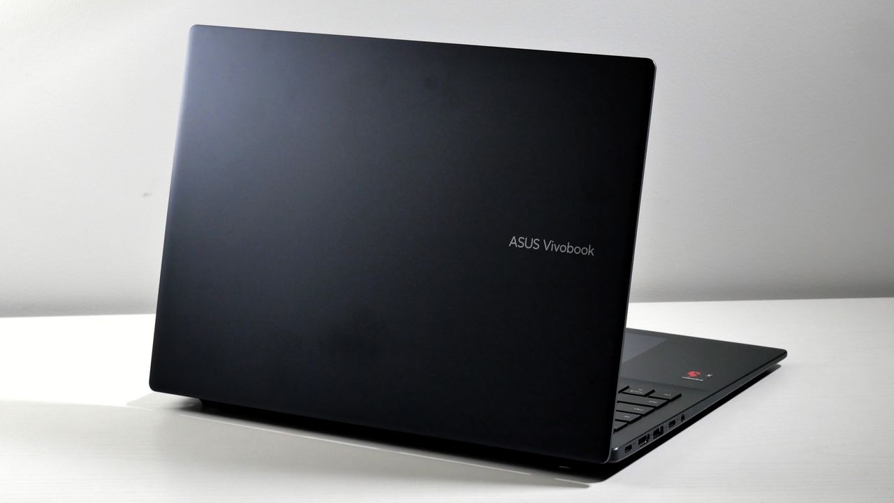 Asus Vivobook 16 (2025) open on a white table, highlighting its dark top lid.
