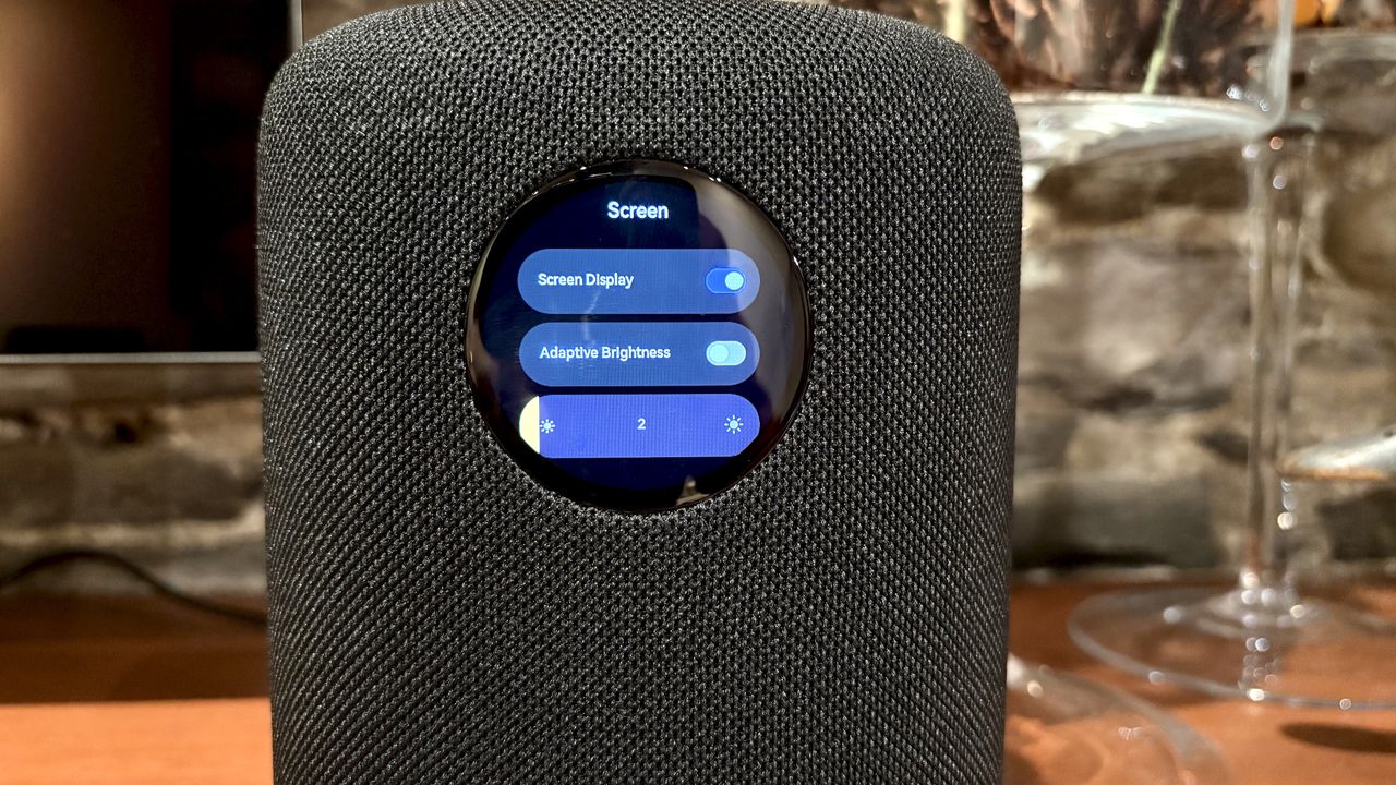 The WiiM Sound, in a home, on a varnished wooden table, showing the illuminated front panel