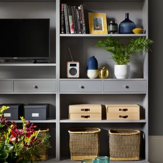 Living room storage boxes in grey shelving