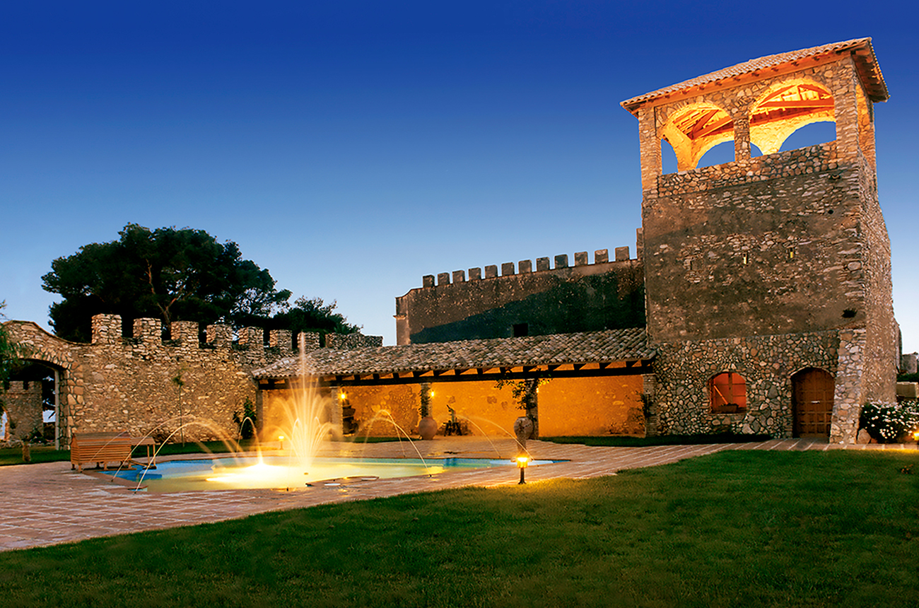 Winery at night with a fountain in front of it