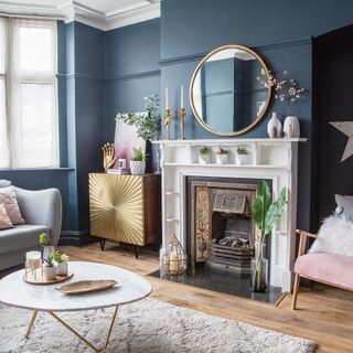 Blue living room with gold accents and period-style white fireplace