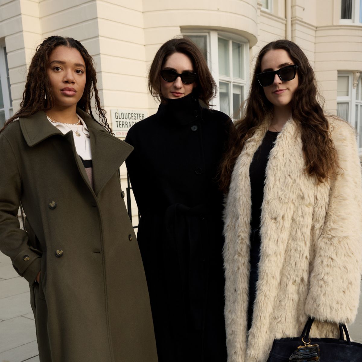 Three editors wear green coat, black coat and shearling coat