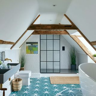 bathroom with white bathtub and printed blue tiled flooring