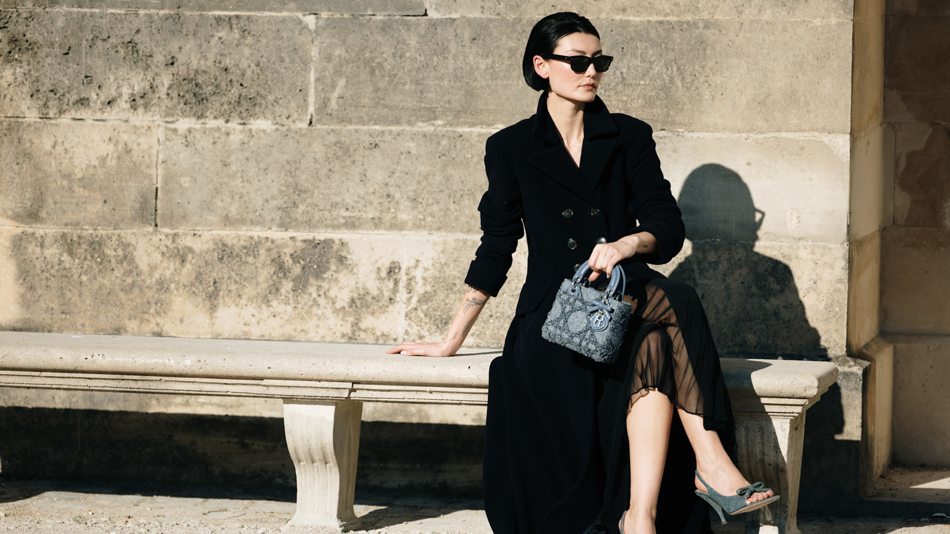 woman holding a bag on a concrete bench