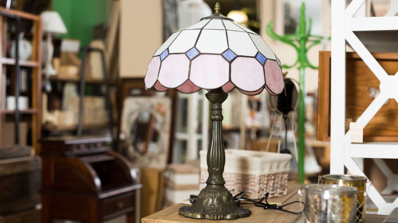 Tiffany style lamp with pink and white shade, with steel base in antique shop