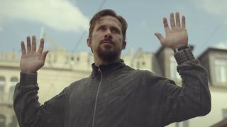 Ryan Gosling with his hands up in The Gray Man