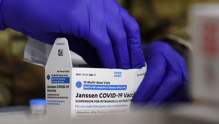  An Army medic removes vials of Johnson & Johnson COVID-19 vaccine from a box at a vaccination site. 