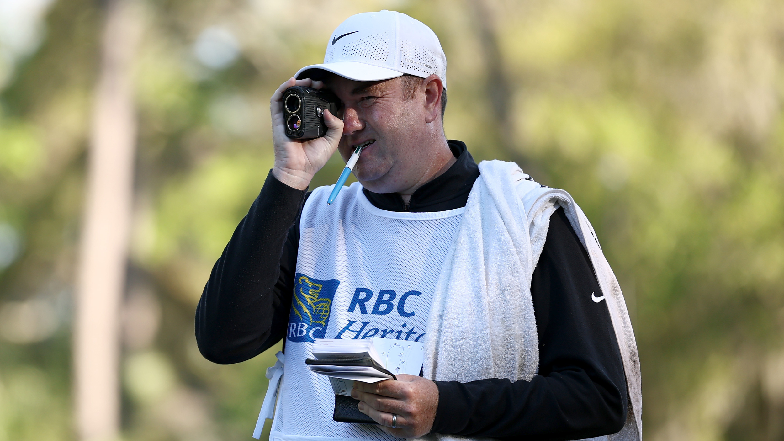 Robert MacIntyre's caddie using a rangefinder