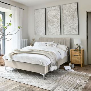 Neutral bedroom with artwork and rug
