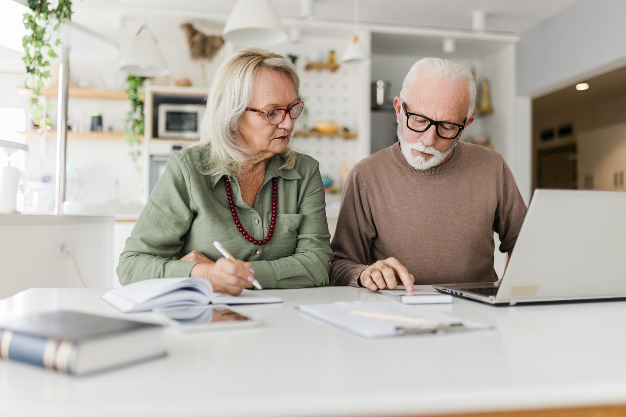 Senior couple using laptop while planning their home budget